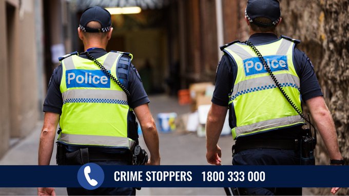 Victoria Two Officers From Behind on Foot Patrol plice walking with crime stoppers banner